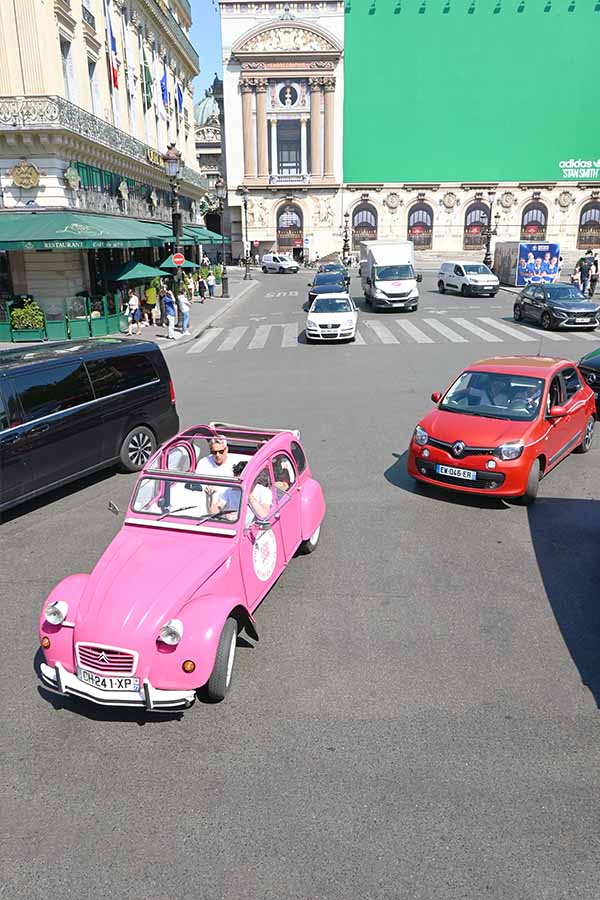 paris-france-bright-pink-vintage-convertible-car-driving-through-a-city-intersection