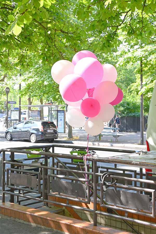 paris-france-bundle-of-pink-and-white-balloons-tied-to-a-railing-along-a-tree-lined-street