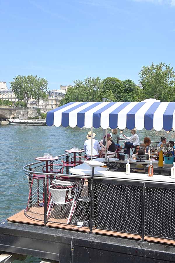 paris-france-floating-riverboat-bar-with-a-blue-and-white-striped-awning-on-the-water