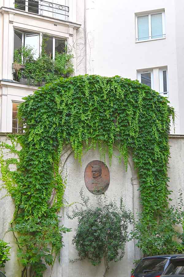 paris-france-lush-green-ivy-archway-surrounding-a-sculpted-wall-relief-medallion