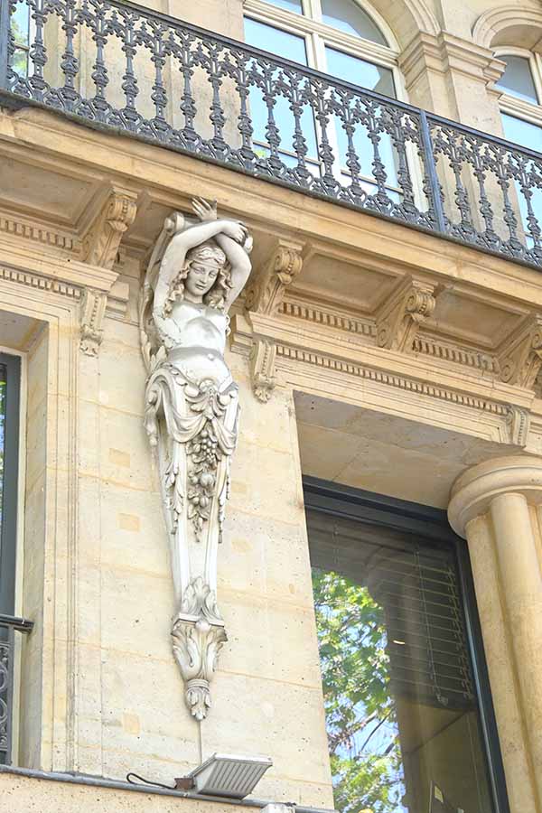 paris-france-ornate-stone-caryatid-statue-supporting-a-wrought-iron-balcony