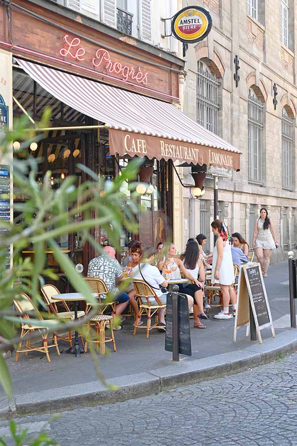 paris-france-patrons-enjoying-drinks-at-the-outdoor-patio-tables-of-a-classic-corner-cafe