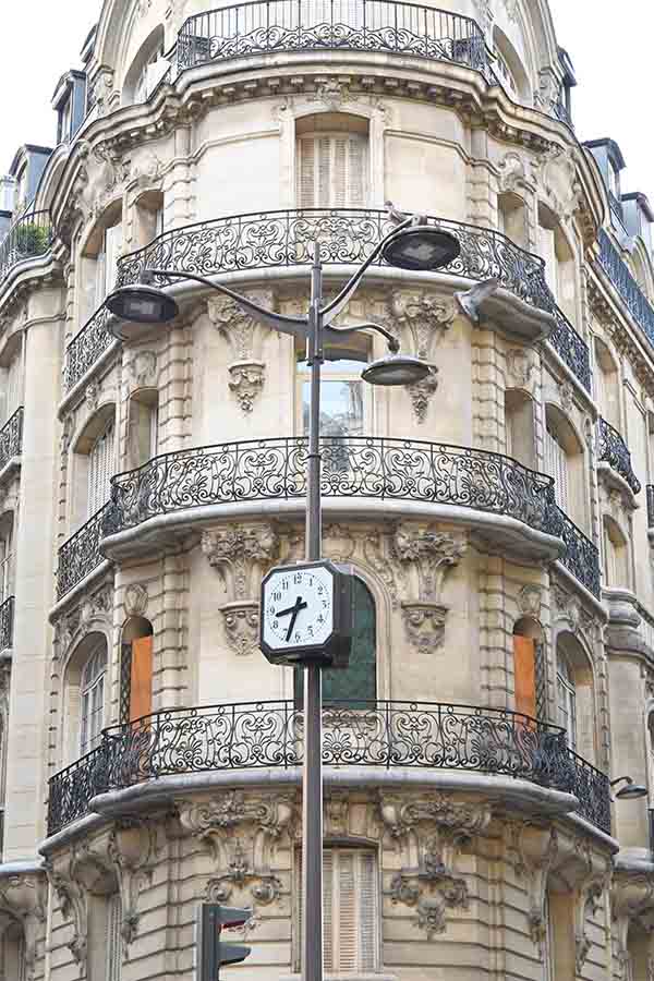 paris-france-street-clock-post-standing-in-front-of-a-classic-haussmannian-corner-building
