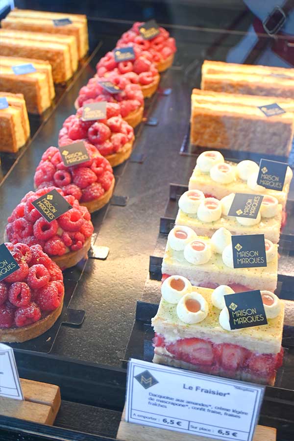 rows-of-fresh-raspberry-tarts-and-layered-strawberry-fraisier-cakes-on-display-at-a-parisian-patisserie