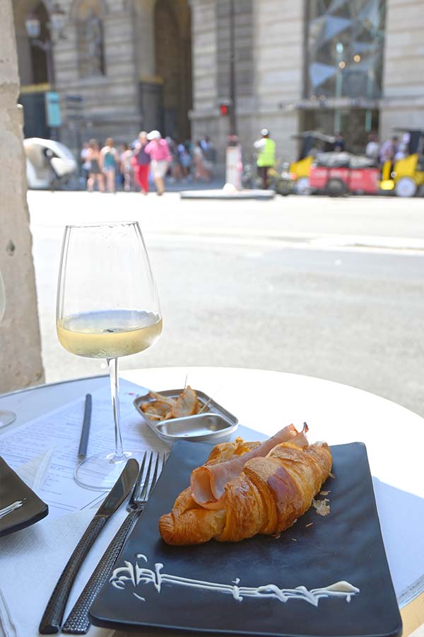 savory-ham-croissant-served-with-white-wine-at-an-outdoor-parisian-cafe-terrace