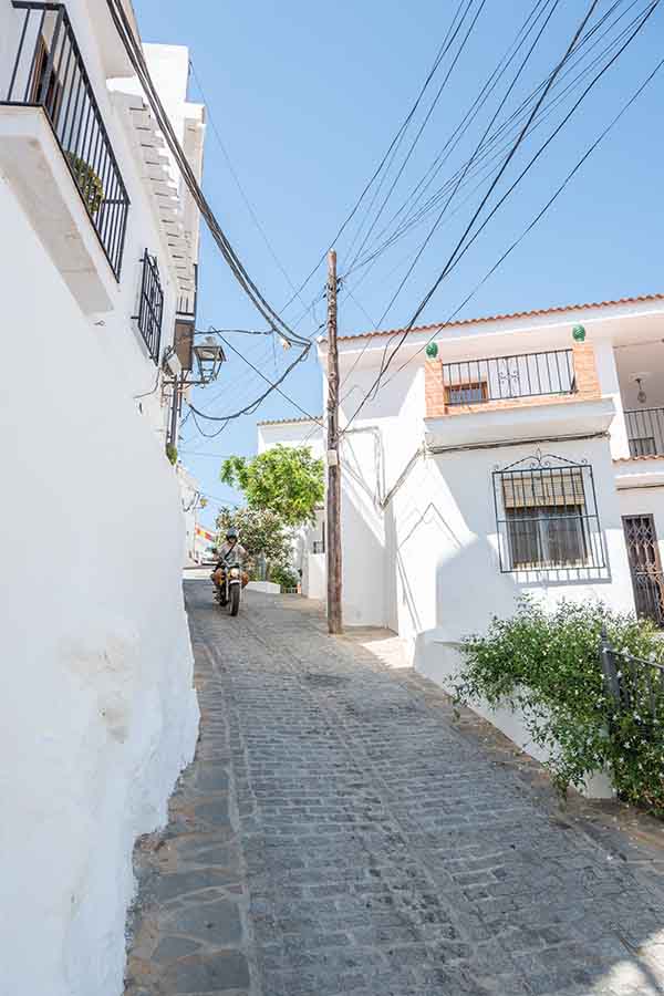 cobblestone-uphill-street-motorcyclist-Almachar-Spain-white-villages-Andalusia