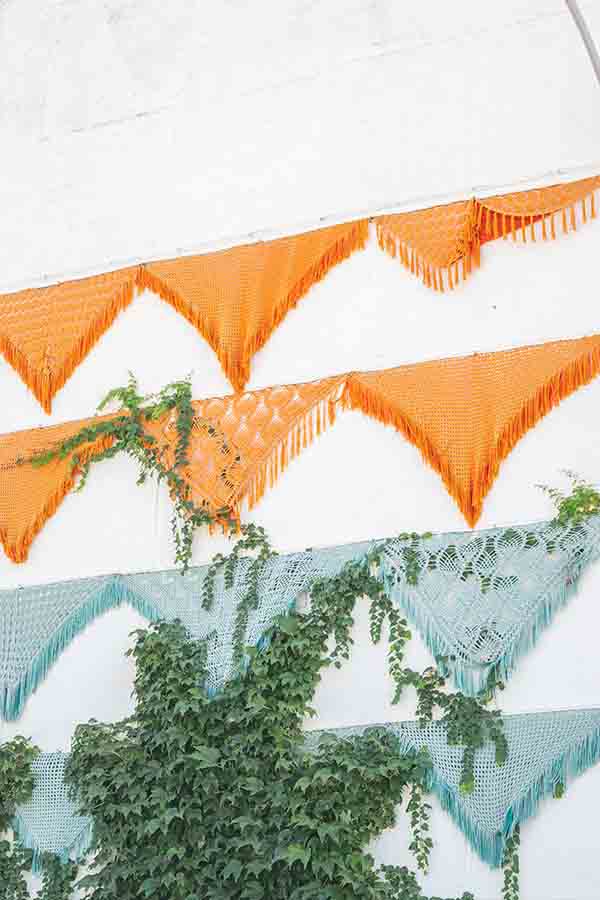 crocheted-festive-bunting-green-ivy-wall-Almachar-Spain-white-villages-Andalusia