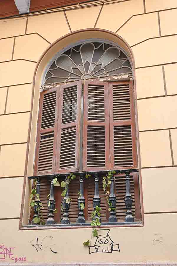 elegant-arched-window-with-wooden-louvered-shutters-highlighting-vintage-travel