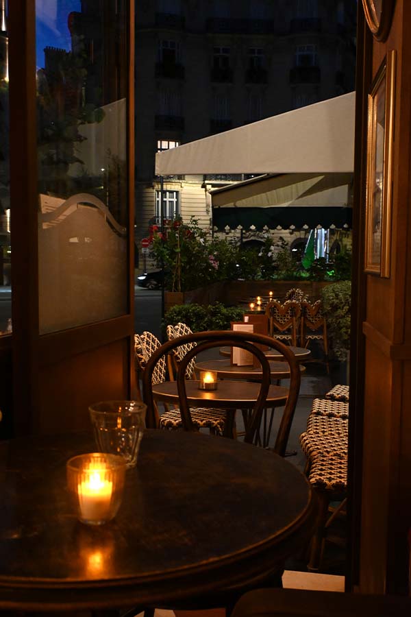 night-photography-candlelit-tables-at-a-cafe-patio-viewed-from-inside