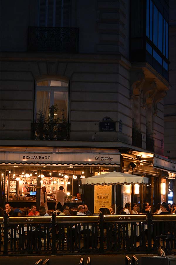 night-photography-corner-restaurant-terrace-filled-with-diners-under-a-lighted-canopy