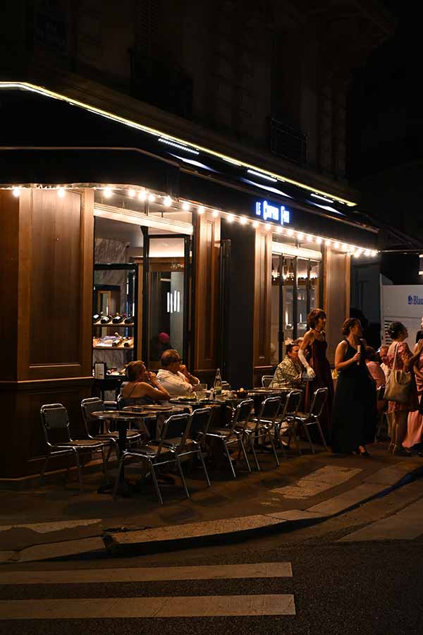 night-photography-exterior-of-a-parisian-bistro-with-outdoor-seating-under-a-lighted-awning