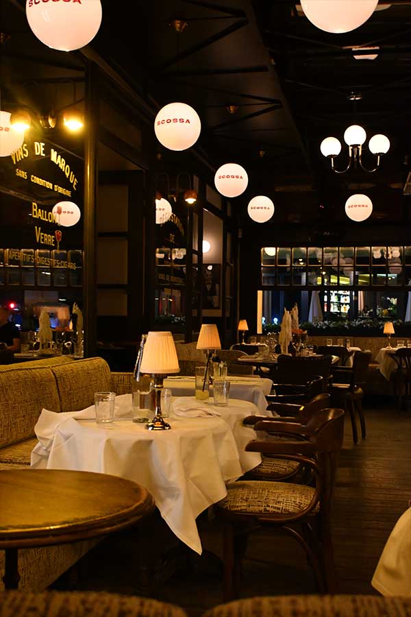 night-photography-restaurant-dining-room-lit-by-glowing-globe-pendant-lights-and-small-table-lamps