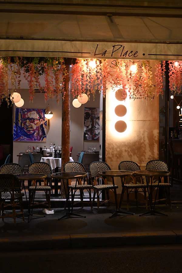 night-photography-restaurant-terrace-decorated-with-hanging-pink-flowers-and-warm-lighting