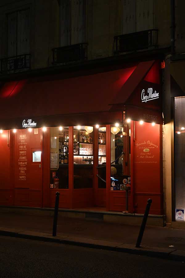 paris-at-night-a-cozy-bistro-façade-with-a-red-awning-and-warmly-lit-windows