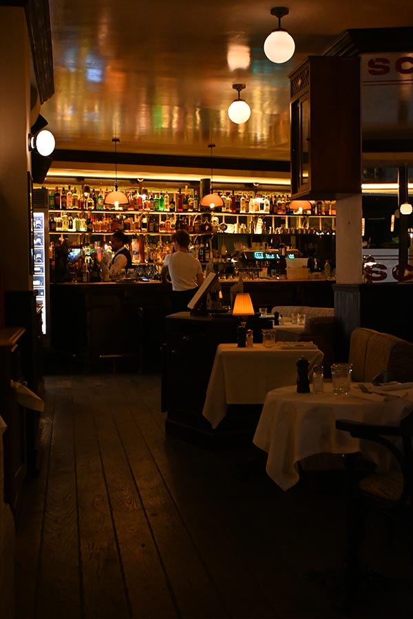 paris-at-night-dimly-lit-bistro-interior-featuring-a-well-stocked-bar-and-cozy-tables