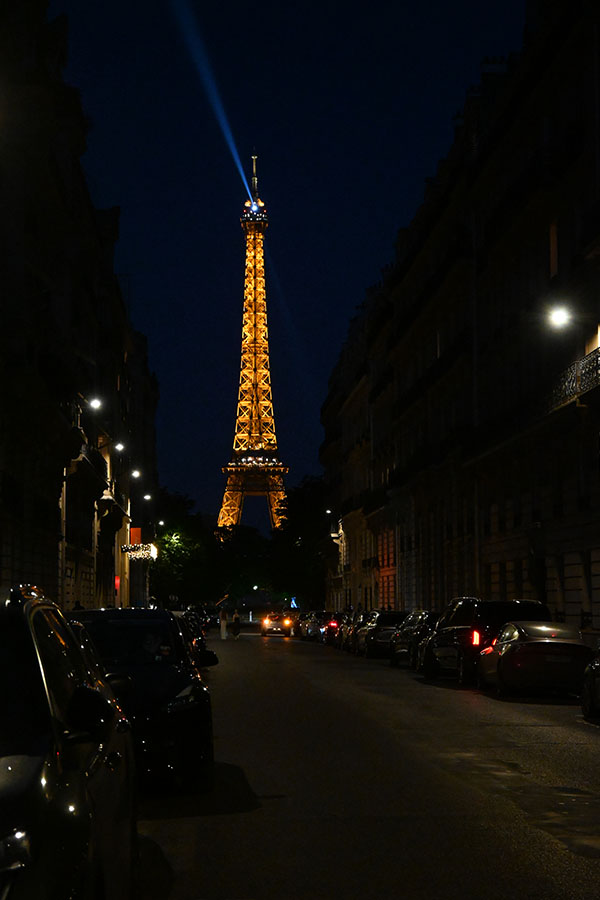 paris-at-night-eiffel-tower-framed-by-a-parisian-street-with-parked-cars