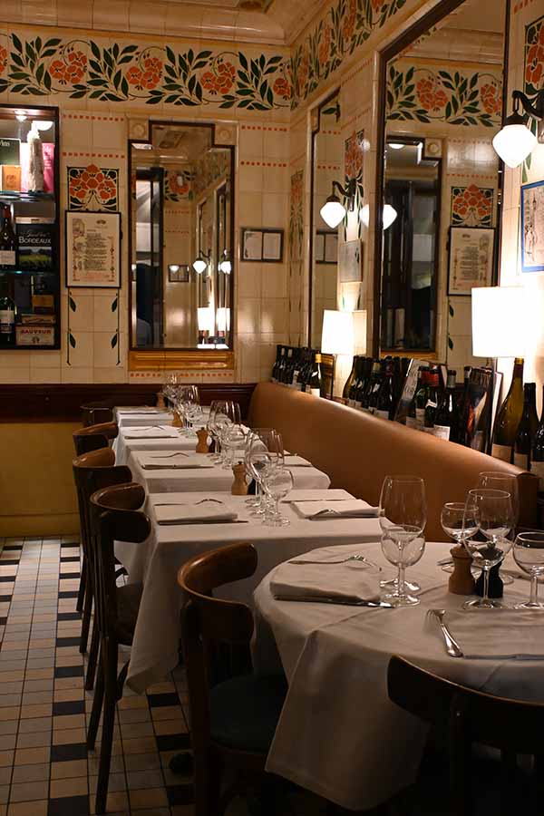 paris-at-night-interior-of-a-charming-bistro-with-tiled-walls-mirrors-and-tables-set-with-white-tablecloths