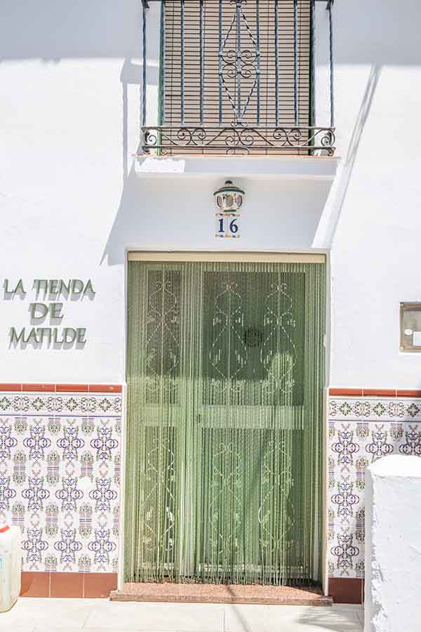 traditional-shop-entrance-tiled-wall-curtain-Almachar-Spain-white-villages-Andalusia