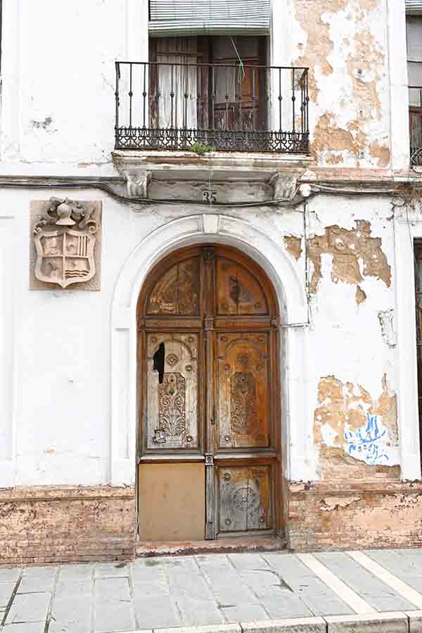 weathered-historic-façade-with-carved-wooden-door-and-coat-of-arms-displaying-vintage-travel